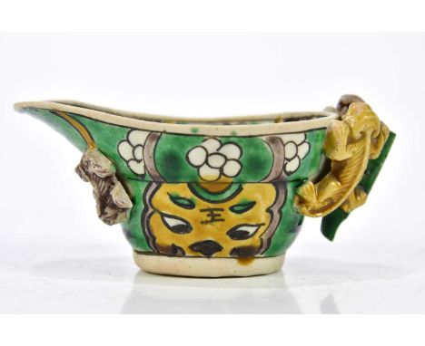 A Chinese Kangxi Famille Verte biscuit porcelain libation cup, with moulded creatures climbing, length 9.5cm, with bill of sa