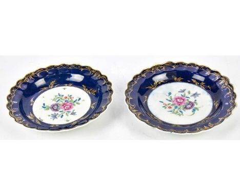 DR WALL; a pair of 18th century Worcester plates with scalloped edges, decorated to the centre with floral sprays inside a gi