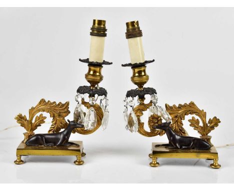 A pair of late 19th century gilt metal candle holders converted to electricity and mounted with bronze dogs, height 26cm (2).