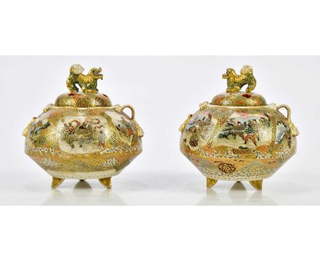 A pair of Japanese Meiji period Satsuma koros and covers, decorated in panels with figures in landscape scenes, bears signatu