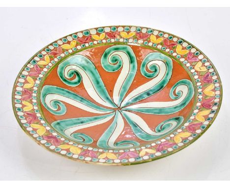 ANN LOUISE JONES AND HARRY PRICE FOR DELLA ROBBIA POTTERY; a footed dish with stylised scrolling detail to the centre, inside