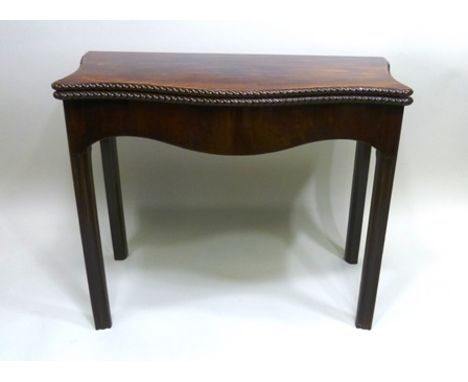 A 19TH CENTURY MAHOGANY FOLD-OVER CARD TABLE, having serpentine shape with gadroon edge, 90cm wide 