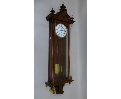 A 19TH CENTURY WALNUT CASED VIENNA WALL CLOCK the case with turned finials, white enamel dial with Roman numerals, eight day 