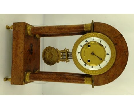 A 19TH CENTURY FRENCH EMPIRE DESIGN PORTICO CLOCK having burr veneer and ormolu case, the dial with enamel chapter ring and R