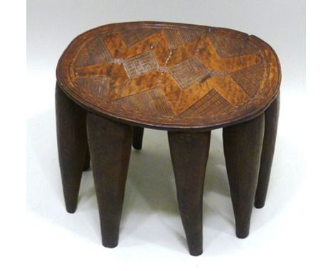 AN AFRICAN NUPE HARDWOOD STOOL carved from one piece of timber with nine spider leg tapering cone supports, the seat chip car