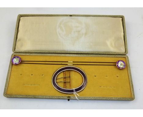 AN EARLY 20TH CENTURY ENAMEL SUITE comprising a large oval mauve and white buckle and two hat pins, cased 
