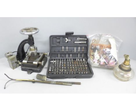 A collection of watch makers tools includes a professional case opener, a watchmakers blacking lamp, buffers and polishers