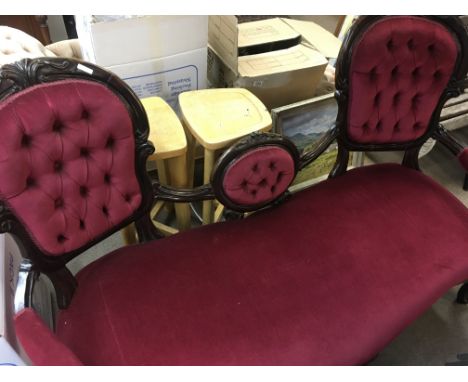 A Victorian double ended sofa with button back upholstery on carved Cabriole legs .
