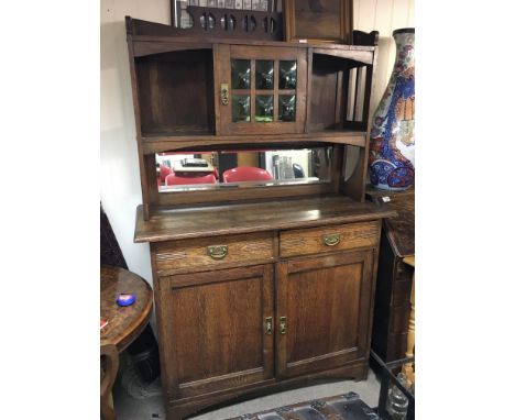 An arts and crafts dresser with raised cupboards, green stained glass, brass fittings. Dimensions 52x120x184cm