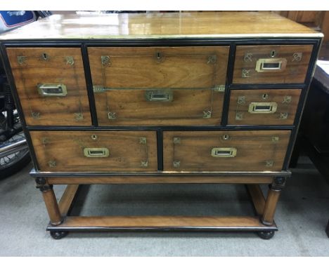 A mahogany brass bound campaign secretaire with five drawers and desk compartment on Stand . 100 cm x 50 cm Height 92 cm .