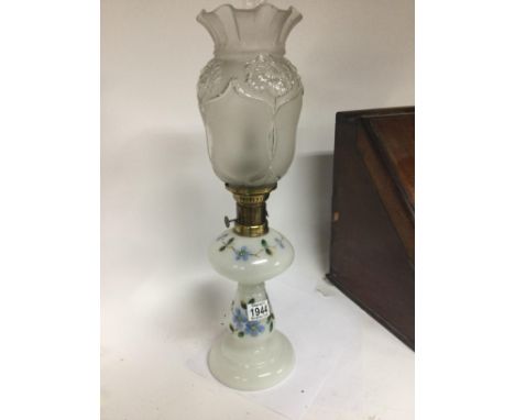 A glass oil lamp painted with flowers the shade with Art nouveau influences.