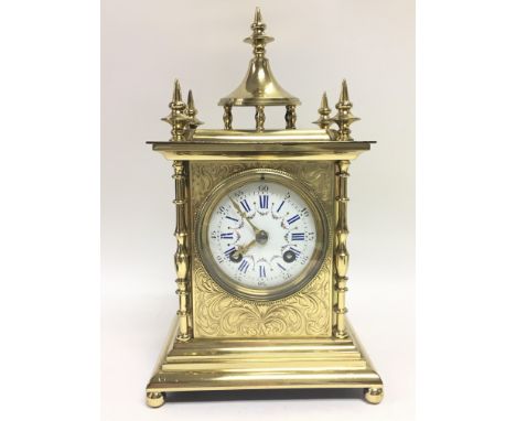 A French brass mantel clock maker S Marti with ornate engraved decoration and a painted porcelain roman numeral dial, with ke