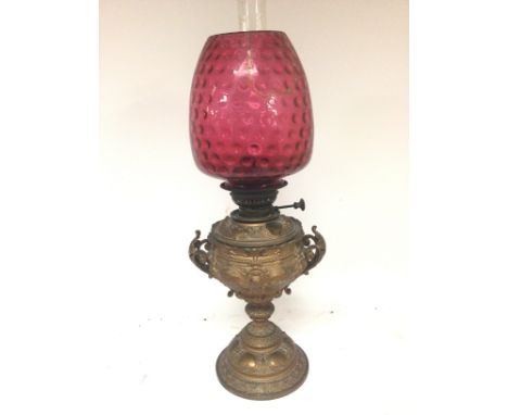 A Victorian gold painted spelter oil lamp with a cranberry glass shade (cracked) NO RESERVE