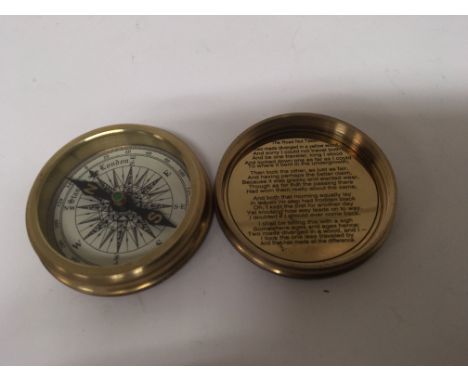 A brass pocket compass the inner case with poem by Robert Frost. The Road Not taken.