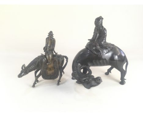 A bronzed metal model of a figure seated atop a buffalo, 28cm high, and another of a (matched) figure atop a horse, 23cm high