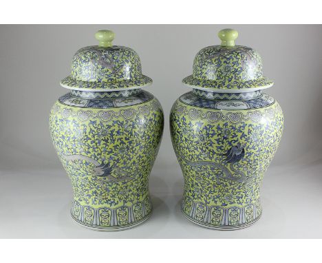 A pair of large Chinese ceramic ginger jars and covers, decorated with dragons amongst flowering foliage, on yellow ground, m