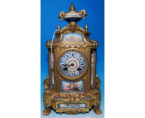 An ornate 19th century Louis XVI style gilt metal and Sevres panel mantel clock with classical vase finial, circular dial and