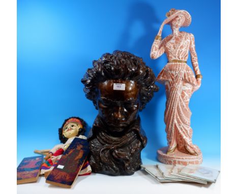 A bronzed head:  "Beethoven"; a marbled statue of a lady; a framed print of a young woman; a Thai puppet; etc.