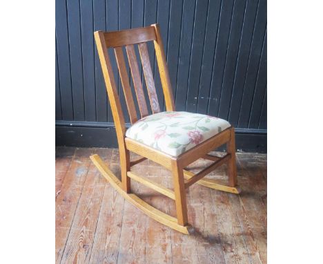 A light oak rocking chair, with slatted back and slip in swept, on swept rockers. 