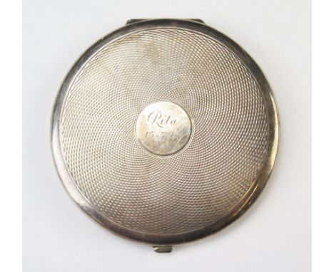 A George Vi silver compact, maker Padgett &amp; Barham Ltd, London, 1945, inscribed and dated, of circular form with engine t