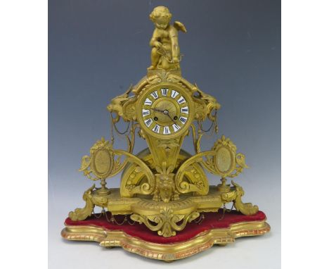 A 19th Century French gilt metal figural mantel clock, the arched and tapering case, surmounted by Cupid drawing his bow, wit