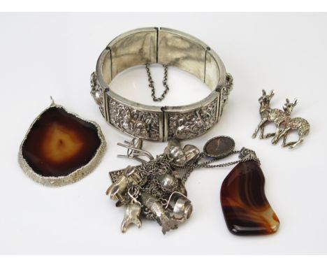 An Indian White Metal Hinged Bangle with six articulated panels having embossed Hindu figures, silver mounted agate pendant, 