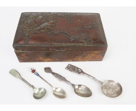 A Japanese antinomy box containing a Chinese silver caddy spoon, and other plated spoons. 