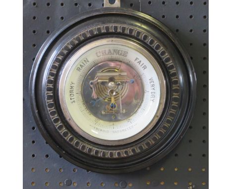 A wall mounted aneroid barometer, of circular outline contained in a mahogany frame, 23cm diameter. 