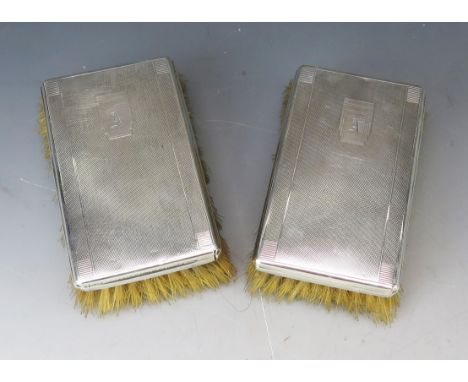 A pair of 20th century silver backed brushes, marks worn, initialled with engine turned decoration. 