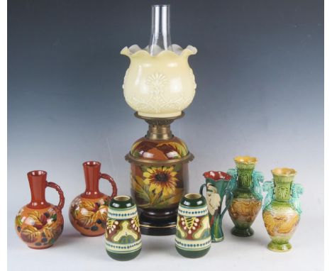 A Watcombe pottery oil lamp with painted sunflower decoration to the stand and reservoir, with later opaque glass shade and g