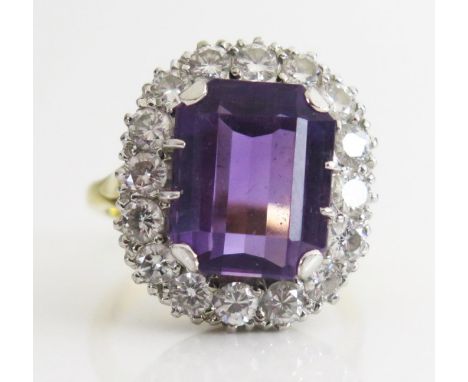 An Amethyst and Diamond Cluster Ring, the 12.5x10mm emerald cut central stone in and 18ct gold setting, 19x17mm head, size K.