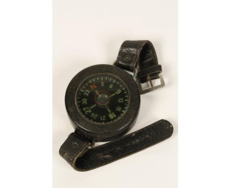 A SECOND WORLD WAR NAZI LUFTWAFFE WRIST COMPASS with a black Bakelite case and original leather straps