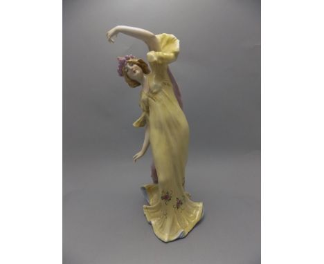 Art Nouveau Hand Painted German Ceramic Figure of a young woman wearing a long flowing yellow dress with a rose garland to he