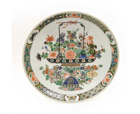 A Chinese Porcelain Dish, Kangxi, of circular form, painted in famille verte enamels with a basket of flowers within a cell b