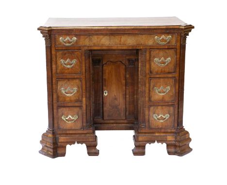 A George I Walnut and Crossbanded Kneehole Desk, early 18th century, the crossbanded and moulded top above an oak-lined friez