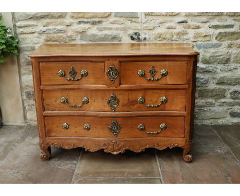 An 18th Century French Chestnut Serpentine Shaped Commode, with two short and two long drawers, above a leaf-carved apron and