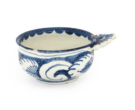 An English Delft Porringer, 18th century, of circular form with single pierced lug handle, painted in blue with a band of sty