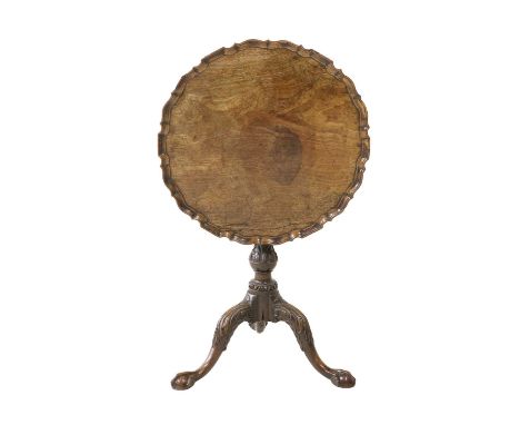 A George II Carved Mahogany Tripod Table, mid 18th century, the circular flip top with pie-crust edge above a fluted and acan