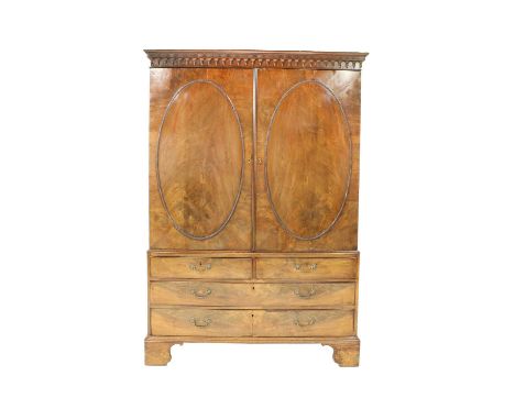 ♦ A George III Mahogany Linen Press, late 18th century, the dentil and arcaded cornice above two cupboard doors with beaded o