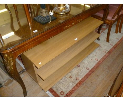 A modern light wood veneered three tier television stand.