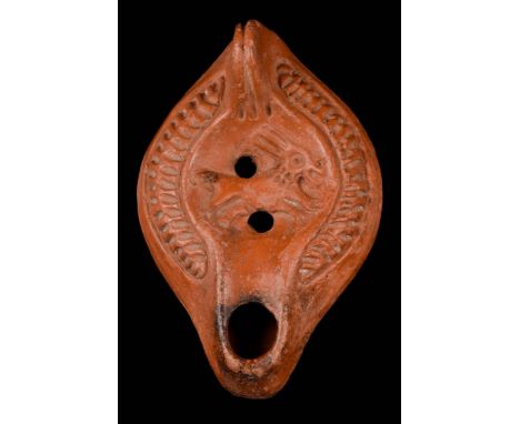 Ca. 300-400 AD A mould-made terracotta oil lamp with a round nozzle, smooth sidewalls, shoulders decorated with a repeating c