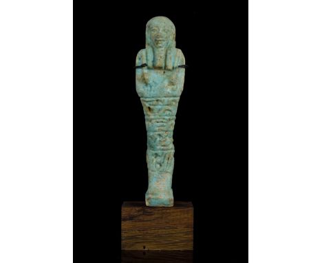 Late Period, 27th - 30th Dynasty, Ca. 525-332 BC This green-glazed moulded figure is mummiform in representation, wearing a p