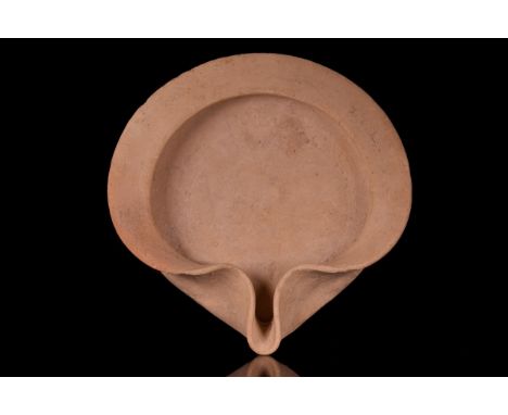 Ca. 6th Century BC A fawn pottery oil lamp of lipped-saucer type with a slightly concave basin, and a flat folded rim, pinche