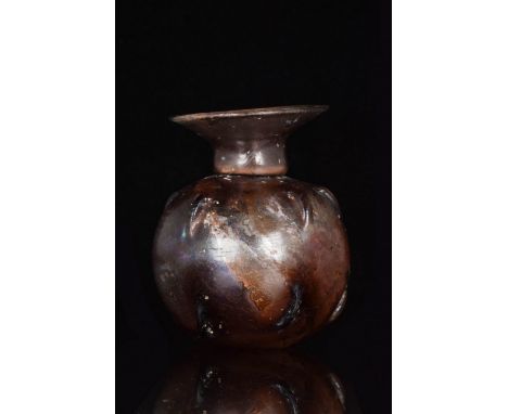Ca. 200-300 AD An aubergine coloured glass unguentarium with a roughly spherical body, a flat base, a stout cylindrical neck,