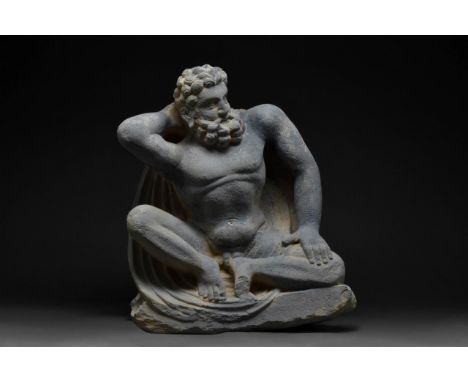 Ca. 200-300 AD A finely polished dark grey schist sculpture representing a kneeling Telamon, inspired by the Greek god Atlas,