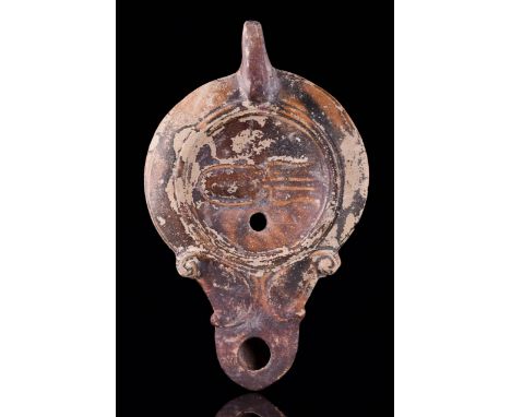 Ca. 1st Century AD A beautiful oil lamp with a concave discus decorated with concentric circles enclosing a central raised oc