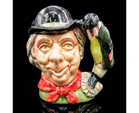 Glazed, hand painted ceramic. The Carpenter is in a green top with a red tied scarf, and black hat. The handle is the Walrus 