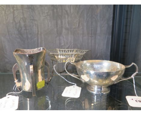 A silver Arts and Crafts style beaker, on four feet, 9 cm high, Goldsmiths and Silversmiths Co. London 1909, a hammered twin 