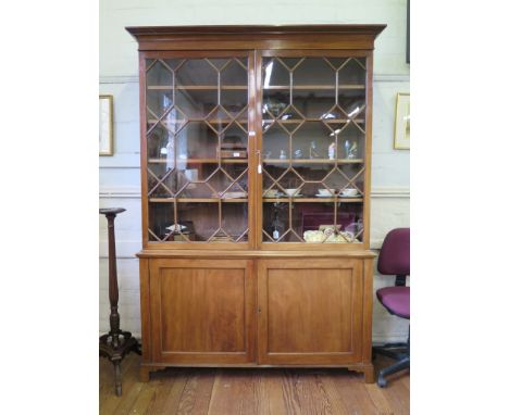 A George III mahogany bookcase cabinet, the moulded top over a pair of astragal glazed doors, above a base with two panelled 