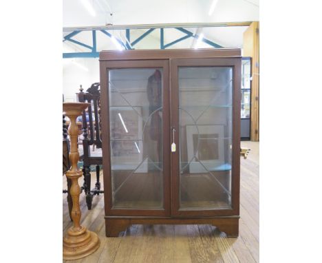 A 1930s oak display cabinet, with twin lead glazed doors on bracket feet, 91 cm wide 